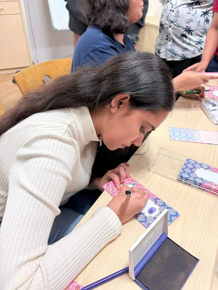 Co-heads personalizing letters with calligraphy and affirmations